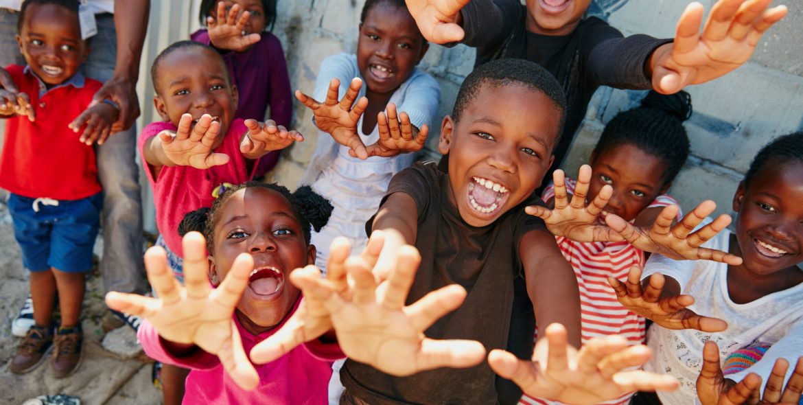 Portrait, outreach and excited with children outdoor for youth drive, community service or welfare project. Rural charity program, poverty and social responsibility with group of kids in neighborhood